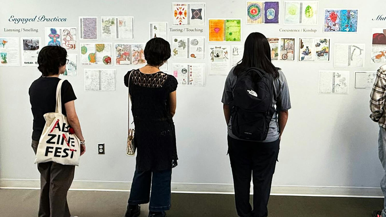people looking at a wall of art